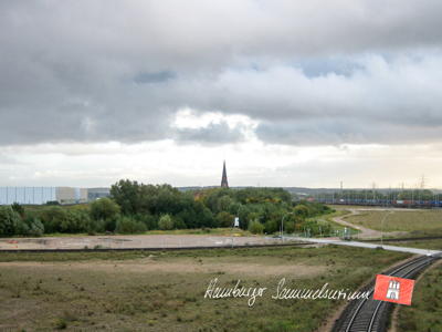 Die Kirche von Altenwerder, links das Containerterminal, rechts die Güterbahn mit der A7.