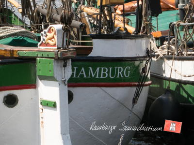 Hamburg am Heck eines Traditionsseglers im Museumhafen.